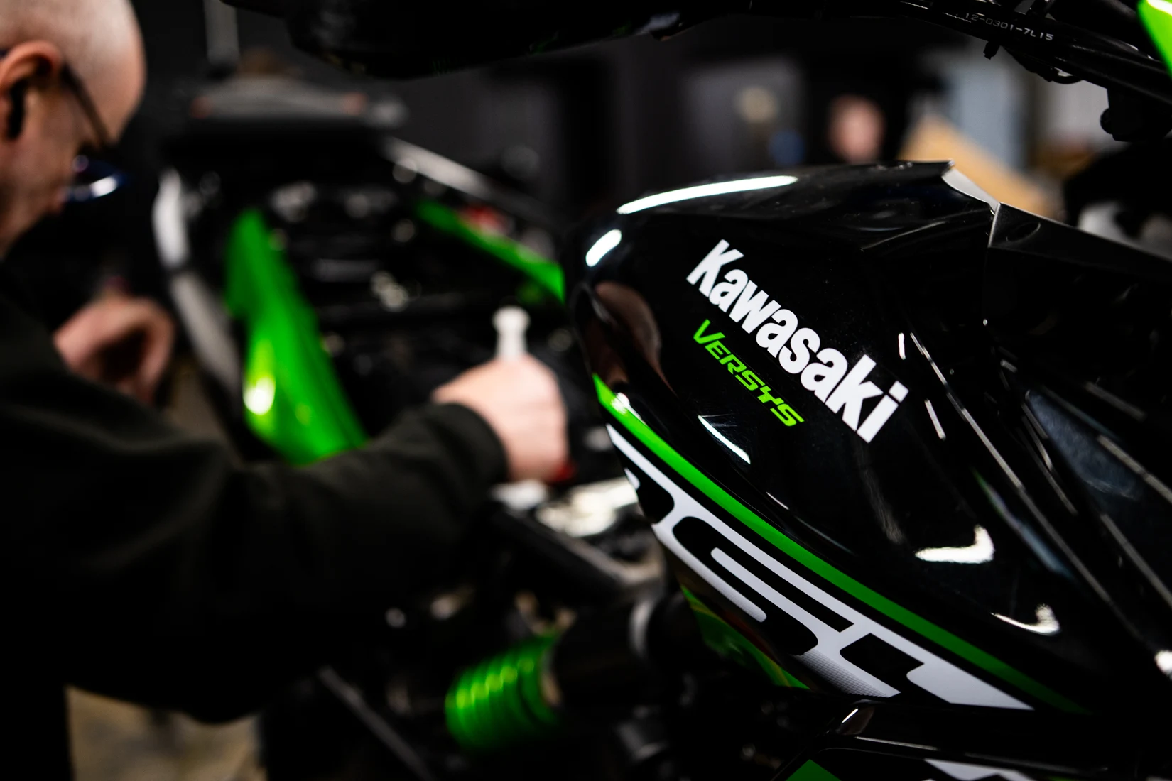 A Kawasaki motorcycle being serviced in a workshop.